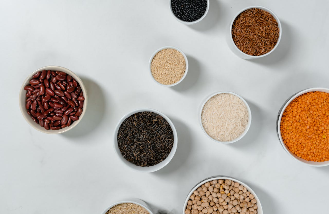 why-choose-us Flat lay of diverse grains and legumes in bowls on a marble surface, highlighting healthy ingredients.
